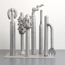 Load image into Gallery viewer, Carol K. Brown (b. 1945 - ) Untitled Sculpture: Six Vertical Elements., 1986 Aluminum Sculpture 53h x 48w x 30d inches Carol K. Brown is a visual artist based in Miami and New York. She began her career as a sculptor, but her work has evolved through numerous phases: anthropomorphic abstractions, figurative paintings, and social commentary. This aluminum statue is composed of six separate pieces on an aluminum base. Available at Manolis Projects Gallery.