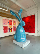 Load image into Gallery viewer, Hunt Slonem’s Blue, glass mosaic, bunny sculpture, Argo. Standing at 122 inches tall and 43 inches wide, it is comprised of hand-cut and formed Italian sheet glass in iridescent blue tones, Argo achieves a most unique light quality that&#39;s at once brilliant in reflectivity and nuanced in its depth of color. The sculpture form itself was based off of Slonem&#39;s new blown glass sculptures. This hunt slonem bunny sculpture and hunt slonem bunny paintings are for sale at Manolis Projects Art Gallery in Miami, FL.
